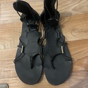 Black sandals with gold accents